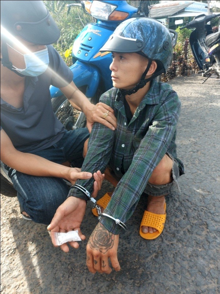 Nguyễn Phùng Thanh Dinh (mặc áo tay dài) và chất ma túy trên tay